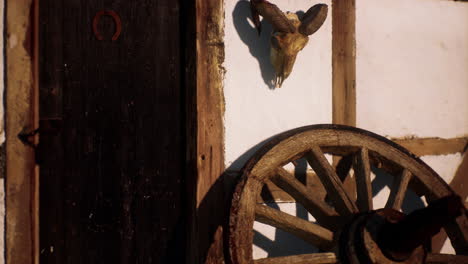 old wood wheel and black door at white house