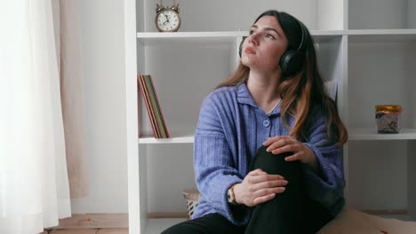 joven disfrutando de la música con auriculares en casa