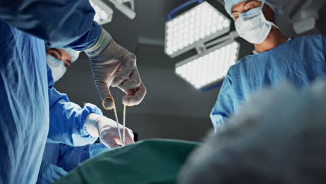 doctors, team and scissors in theater for surgery