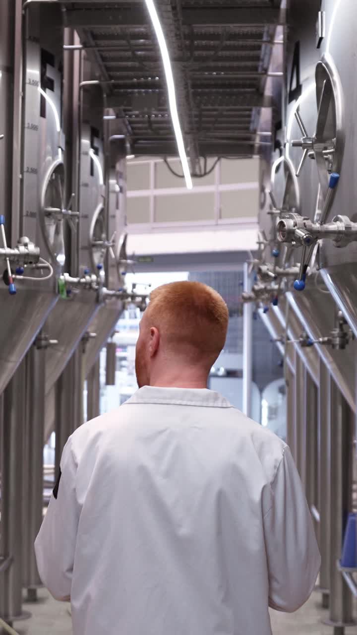 Man in brewery inspecting tanks