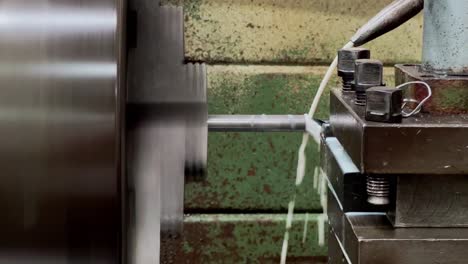 una barra de hierro siendo perforada usando una máquina de fresar