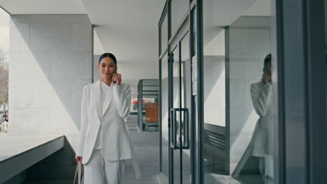 woman manager consulting telephone walking office corridor. lady boss calling