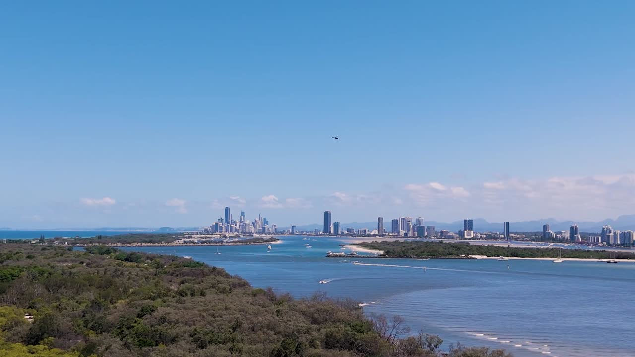 A stunning view of the city skyline across a vibrant waterway, bordered by lush greenery.