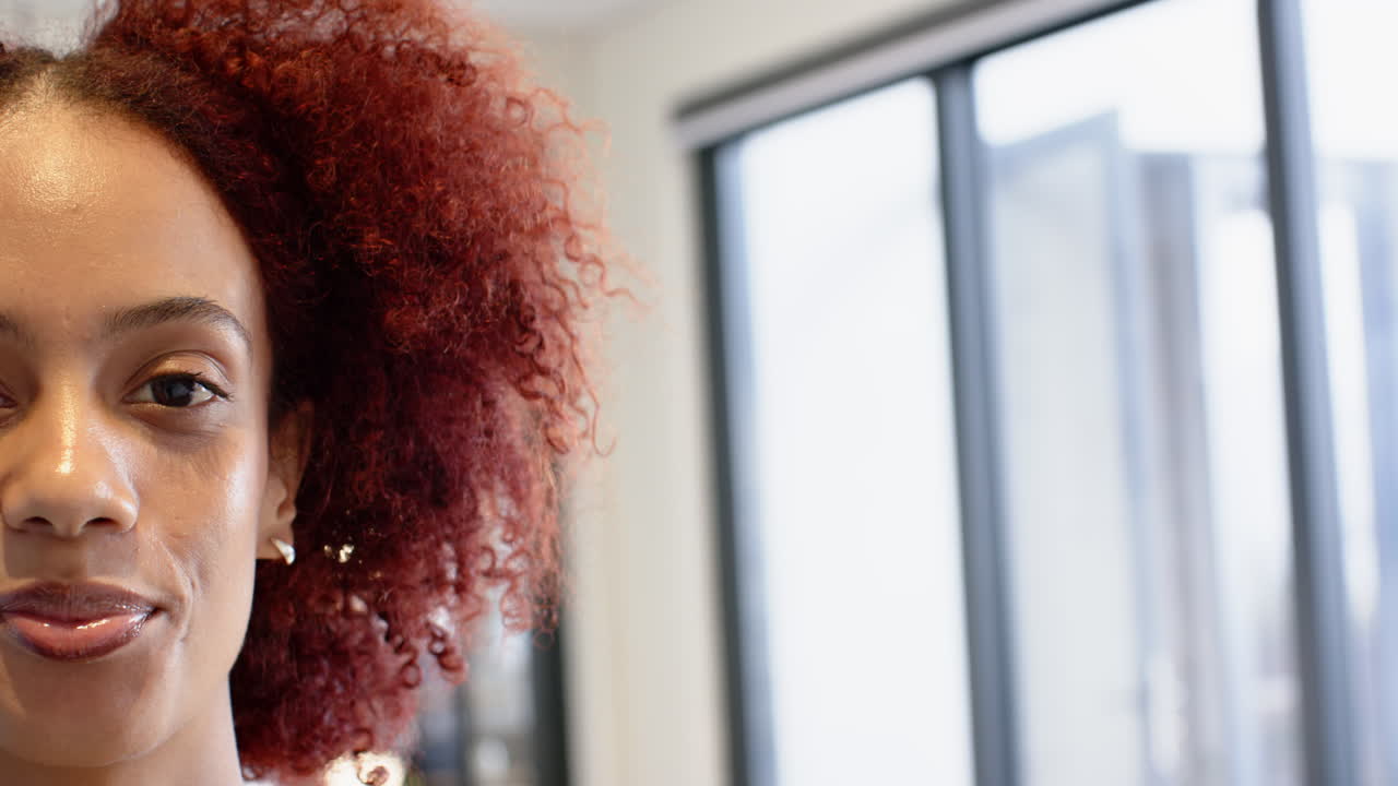 Smiling woman with curly hair in office, focusing on creative writing business, copy space