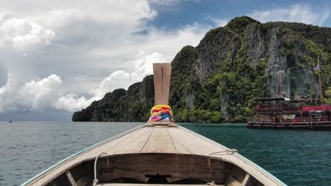 longtail boat ride offers forward-facing view of thailand's southern rocky cliffs near ko phi phi island