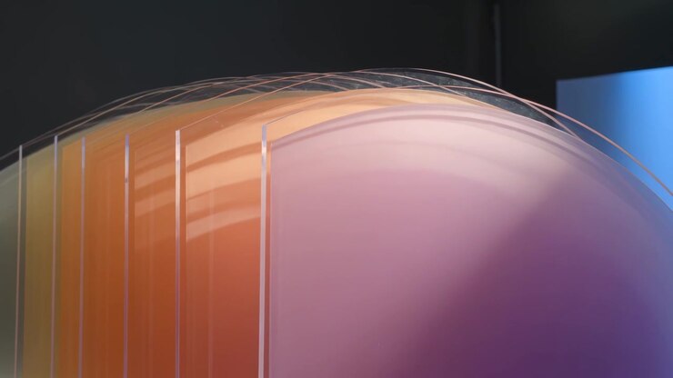 Shifting studio light causing sculpture moving, showing stacked orange panels and purple dome