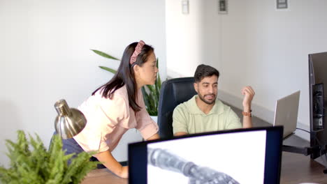 collaborating in office, colleagues discussing project on robotic arm on computer screen