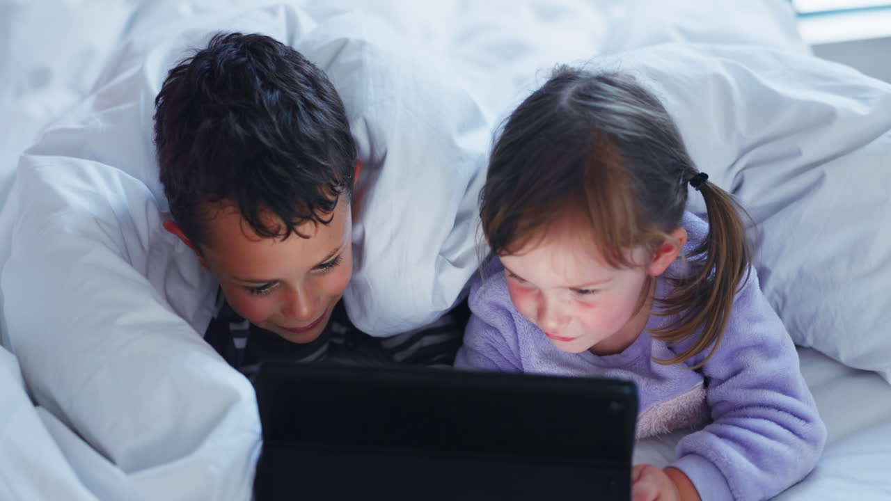 소년, 소녀 또는 태블릿을 가진 형제자매