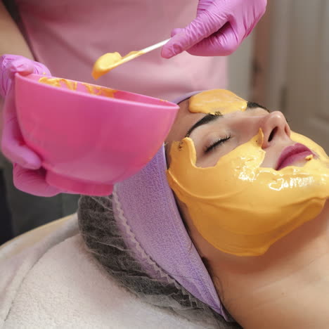 face peeling mask. woman getting facial care by beautician at spa salon. cosmetologist job. close-up