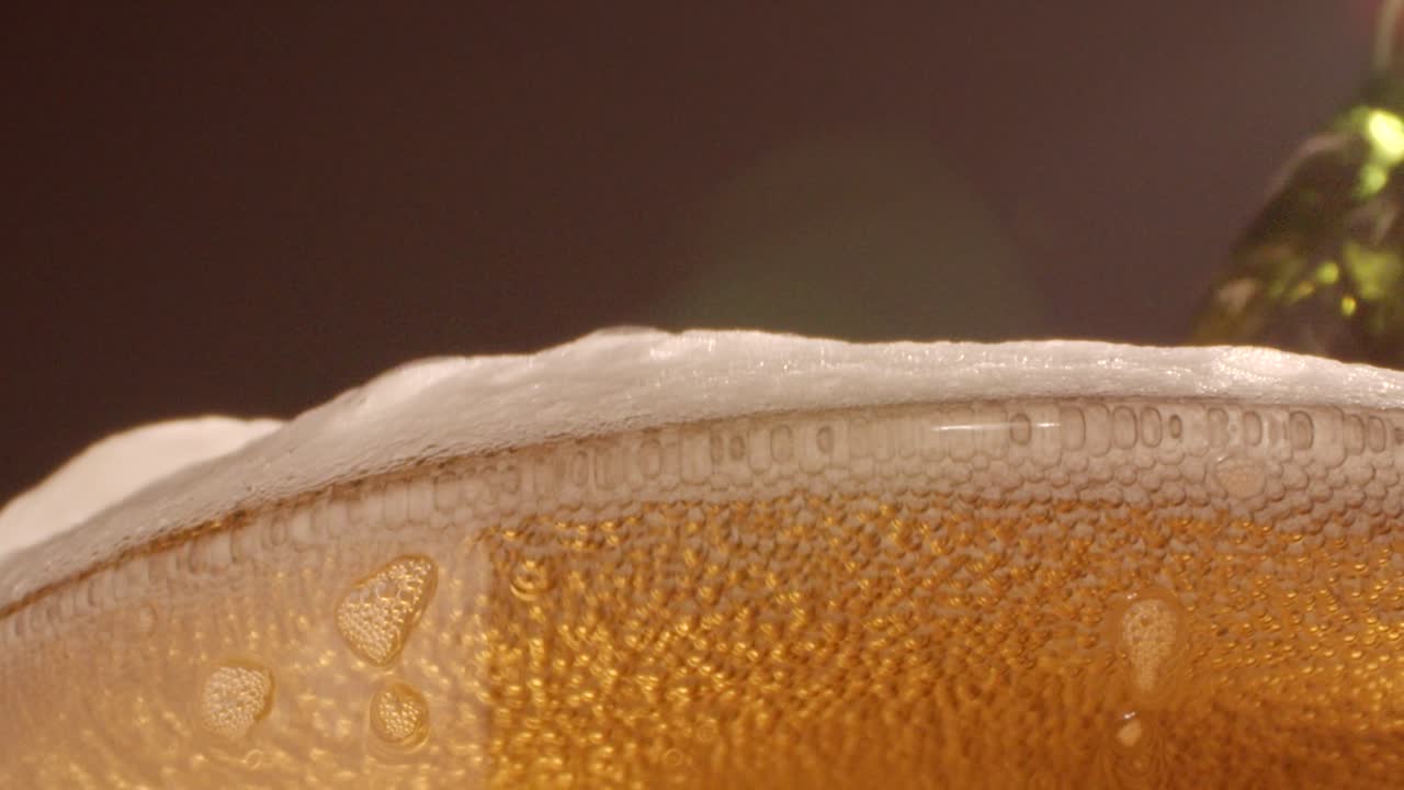 cerveza con espuma derramándose sobre el vidrio