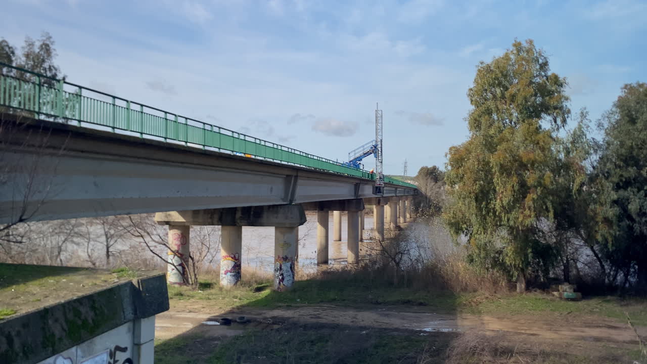 Bridge spanning a wide river with some flooding, showing general infrastructure and maintenance work in progress