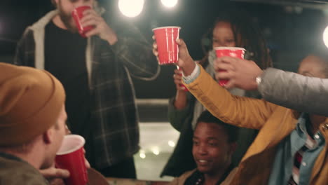 group of friends making toast drinking enjoying rooftop party celebration at night young multi ethnic people having fun socializing hanging out on weekend