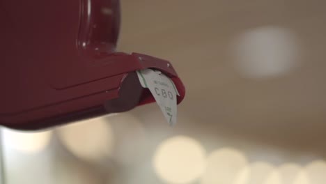 close-up of person taking a paper receipt from a machine in a grocery store