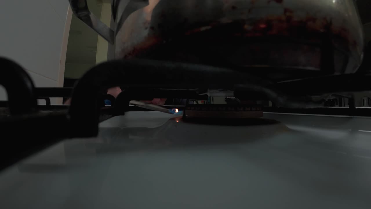 POV (Point of View) of common kitchen activity; saucepan placed on cooktop, gas lighter ignites the gas burner element
