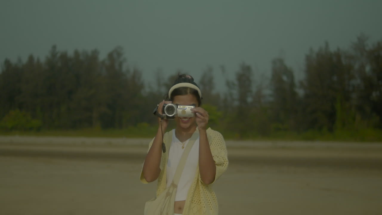 Woman filming outdoors with camcorder, capturing nature's beauty