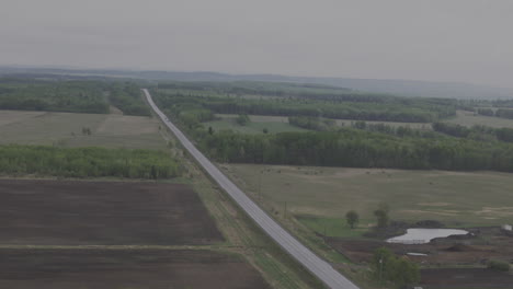 aerial view of an empty road winding through alberta’s wilderness