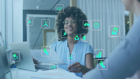 Animación-De-íconos-Ecológicos-Sobre-Diversos-Colegas-Que-Usan-Computadoras-Portátiles-Y-Discuten-El-Trabajo-En-La-Oficina