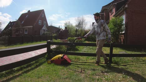 Young-man-cutting-the-grass-with-the-lawn-mower-in-the-yard