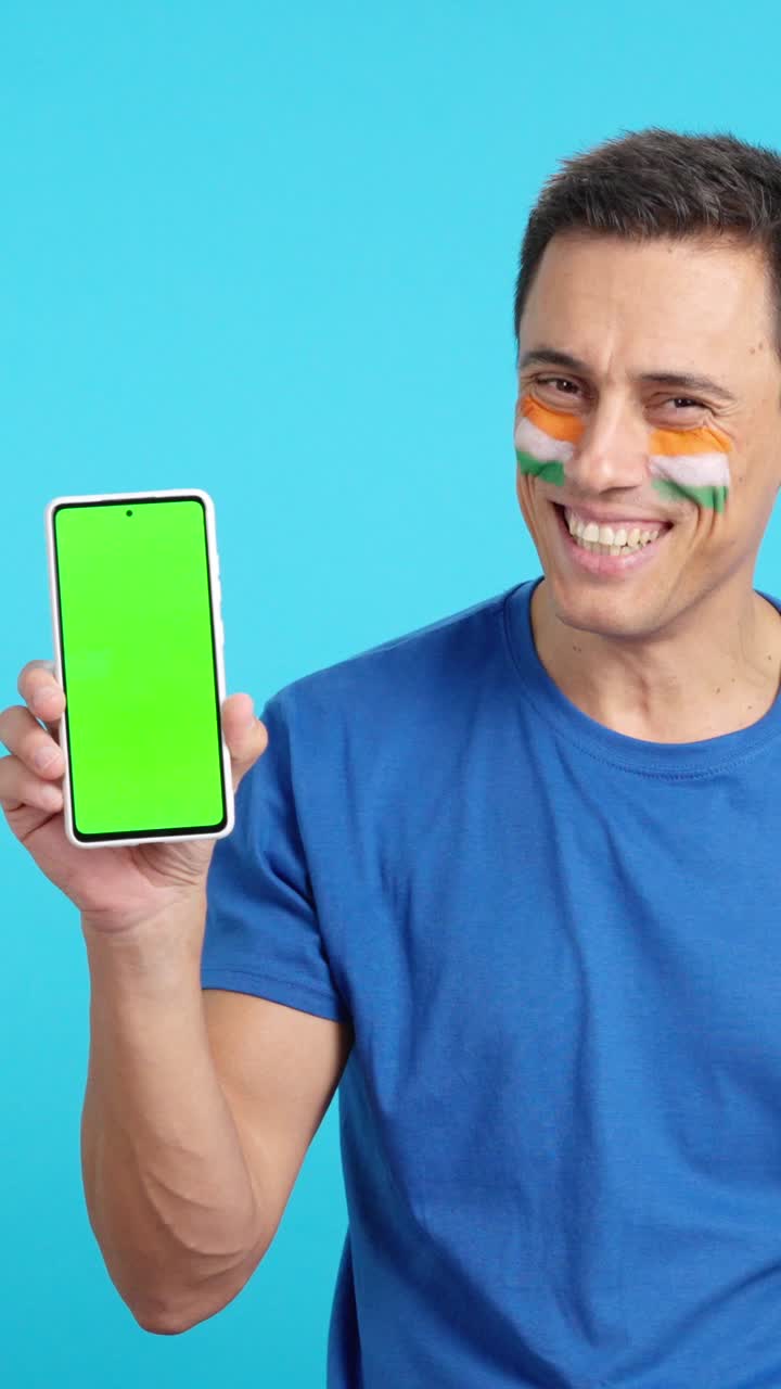 Indian man looking at his mobile smiling and showing it