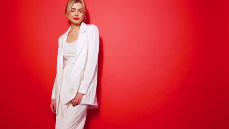 woman in white suit against red background