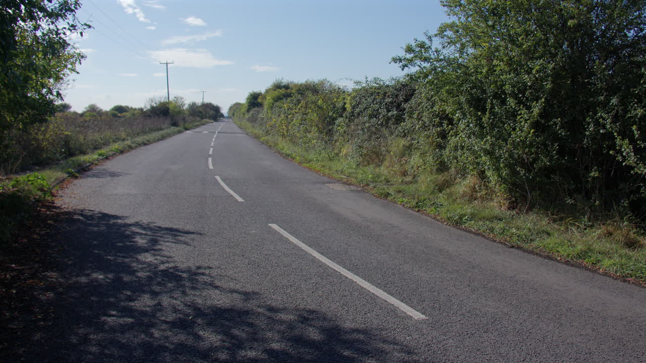 Toma extra ancha de una carretera rural con badenes, en la Isla de Grain, junto a la torre de la batería de Grain.
