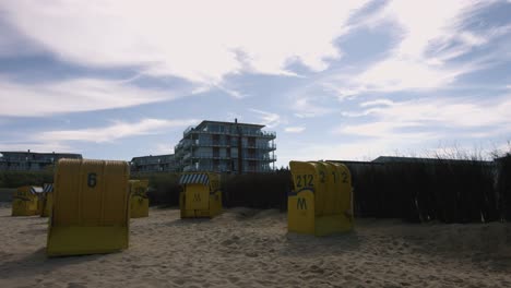 sillas de playa en una playa con un hotel al fondo