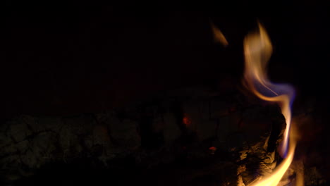 a log burning in a fireplace with yellow flames rising all around it