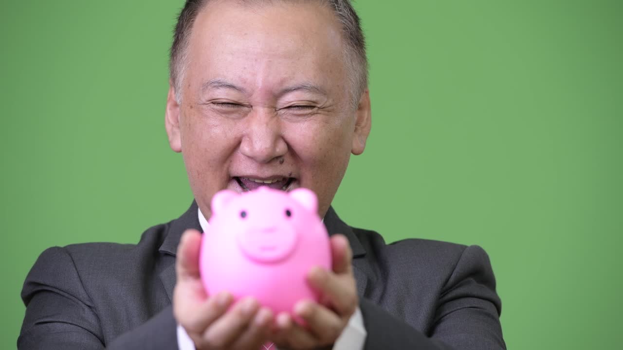 성숙 한 일본인 사업가 가 돼지 은행 을 들고