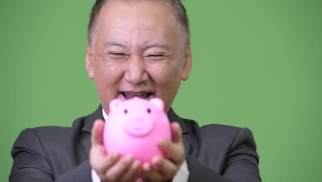 성숙 한 일본인 사업가 가 돼지 은행 을 들고