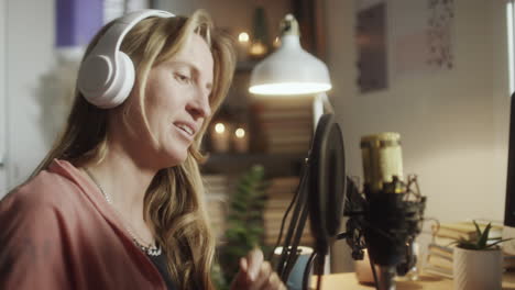 woman recording podcast in evening at home studio