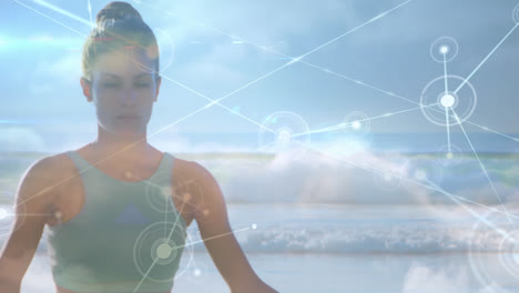 animation of network of connections over woman practicing yoga by the beach