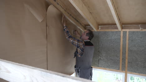 carpenter contractor working on insulated wall, indoors