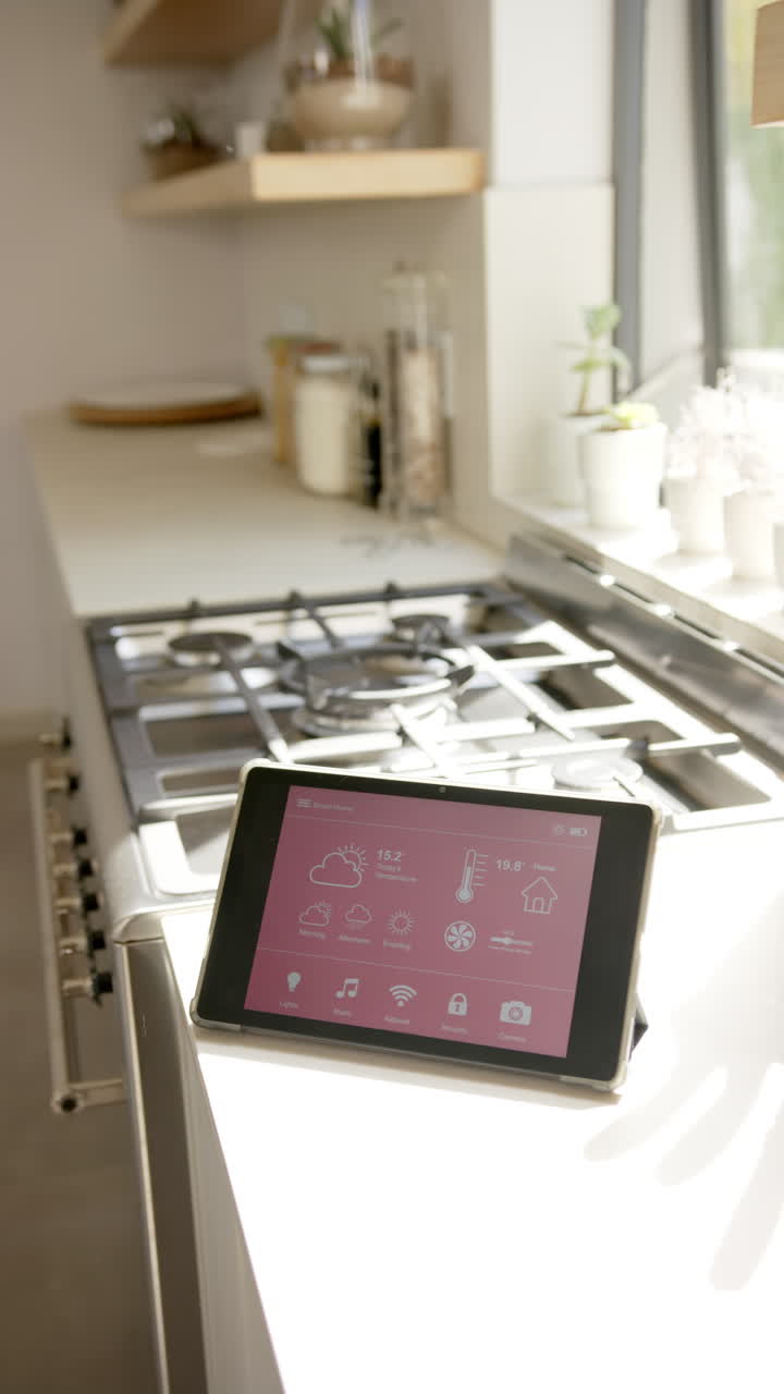 Vertical video: Tablet displaying smart home controls on kitchen counter near stove