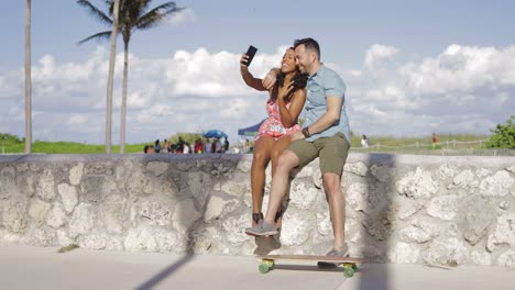 excited couple taking selfie on seafront