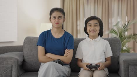 niño indio molestando a su hermana después de ganar un videojuego
