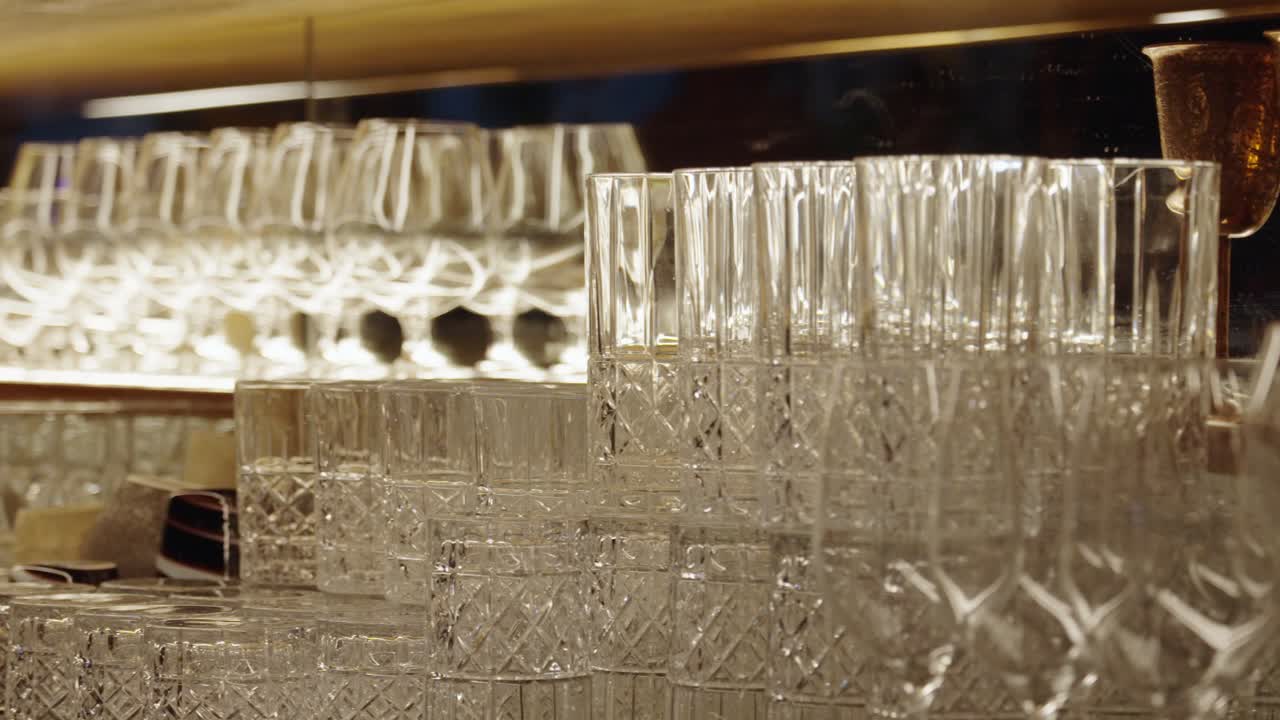 Multiple clean glasses stacked on bar counter. Night club bar