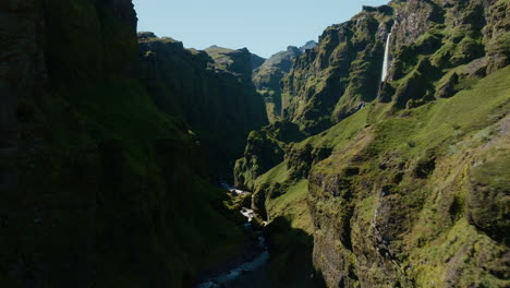 dron aéreo dentro del cañón mulagljúfur, día soleado con sombras, verde y rocoso 01