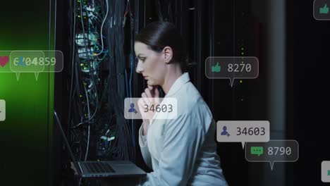 animación de iconos de las redes sociales sobre una ingeniera caucásica que usa una computadora portátil en la sala de servidores