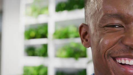 Portrait-of-happy-african-american-businessman-looking-at-camera-and-smiling-at-office,-slow-motion