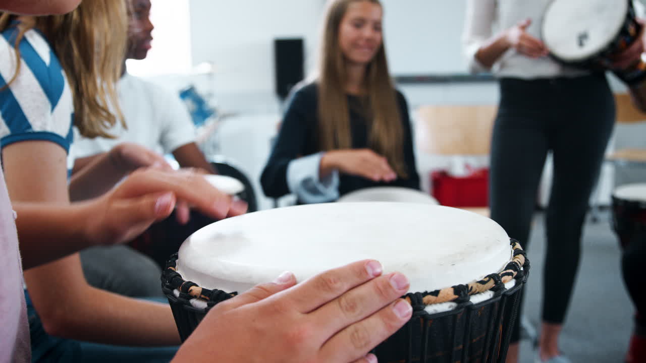 estudiantes adolescentes que estudian percusión en la clase de música