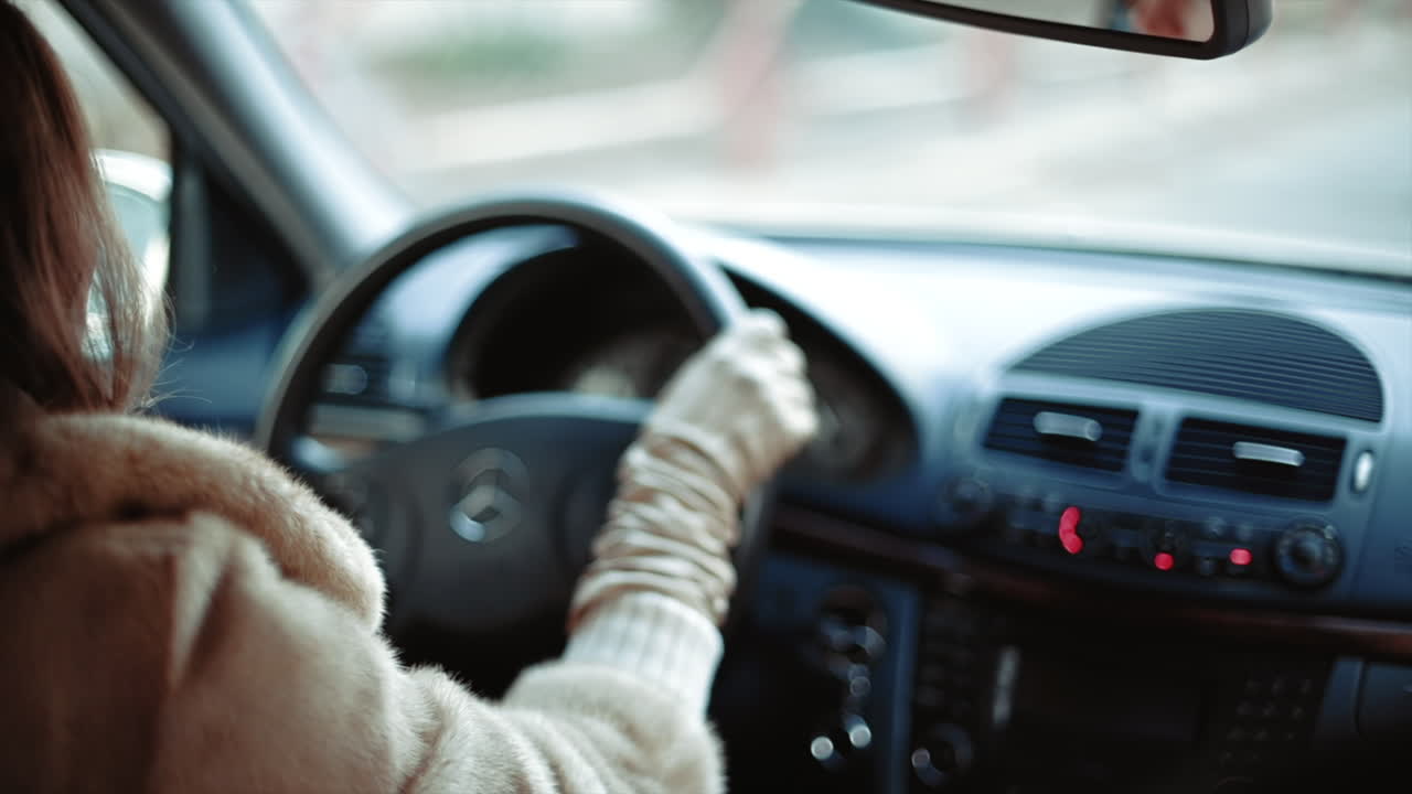 Woman driving a car in slow motion, hands on wheel