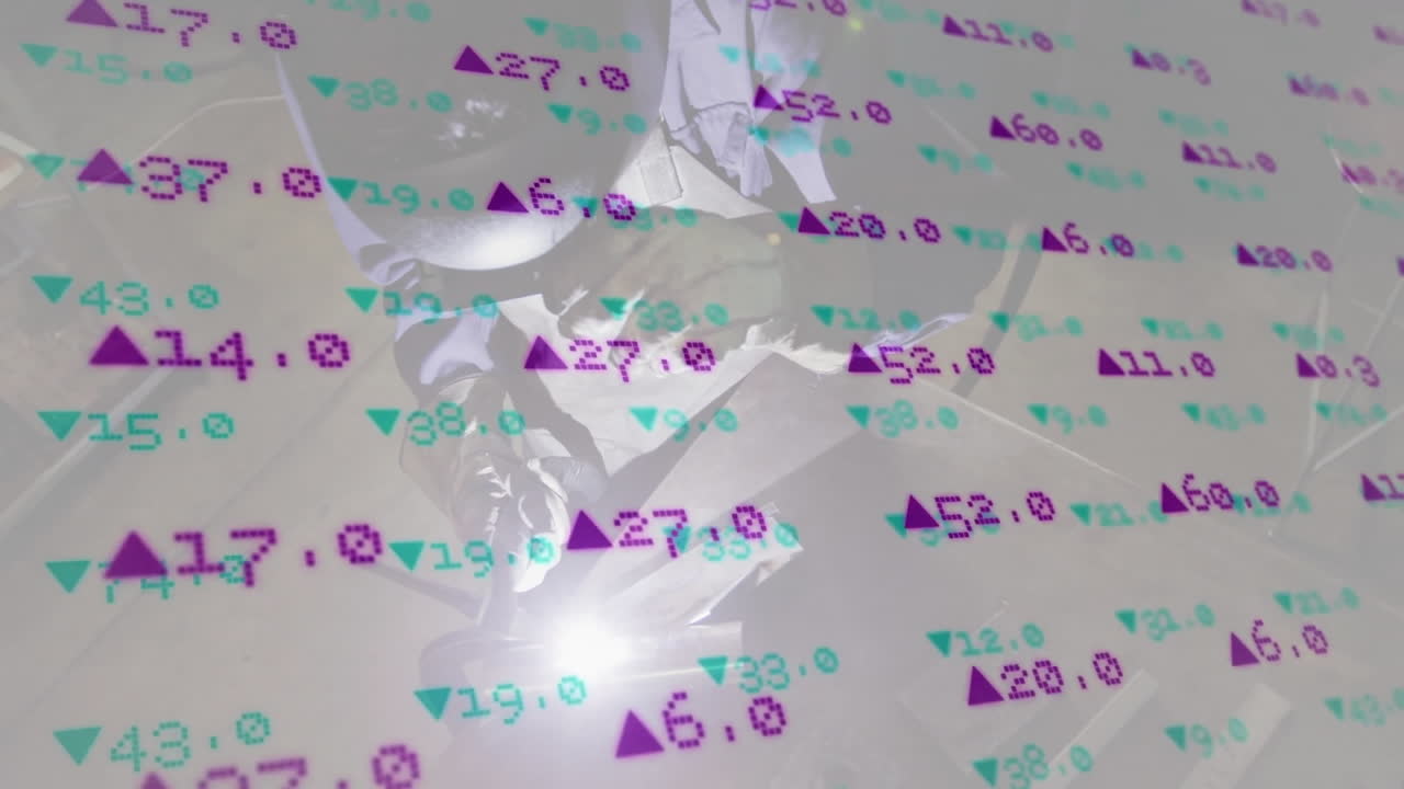 Welder kneeling and welding metal in factory, showing glowing sparks and data overlay metrics