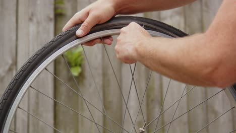 tire lifter being used to remove outer tire from bicycle wheel