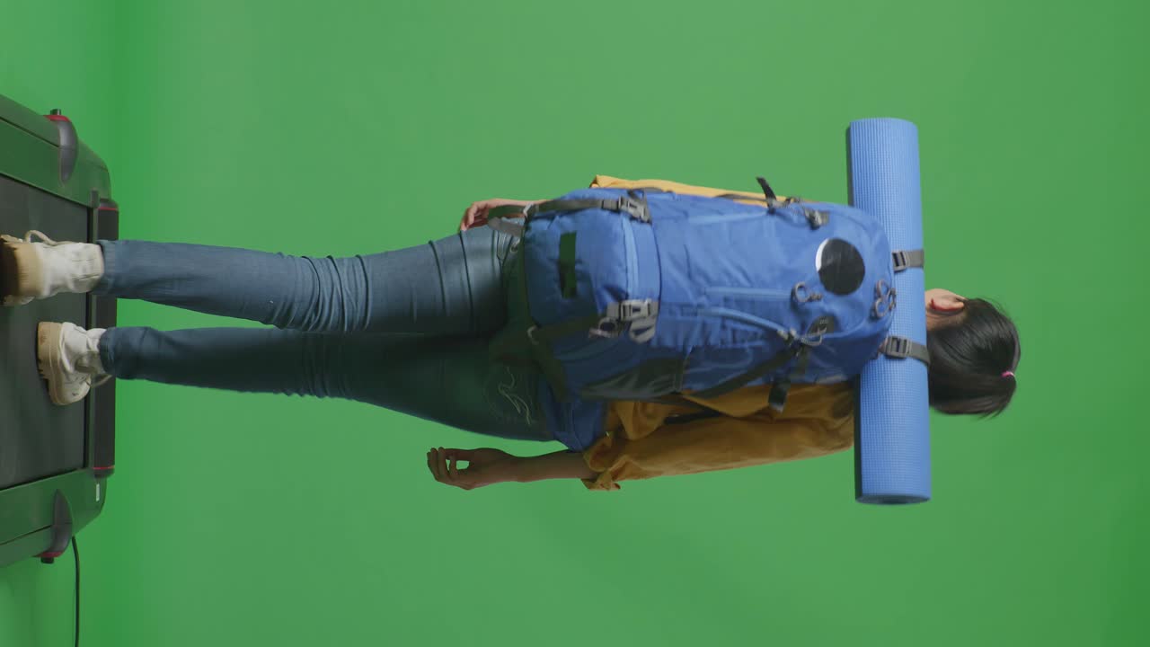 mujer caminando en una cinta de correr con mochila y colchón de yoga