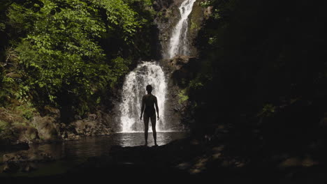 woman stands in front of rha waterfall on isle of skye scotland 4k