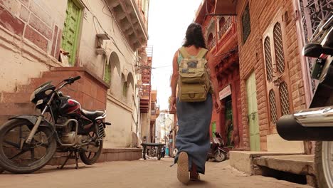 female tourist walks through the streets of an indian city. rajasthan, indian jodhpur also blue city