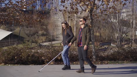 Blind-man-walking-down-the-street-with-his-wife.