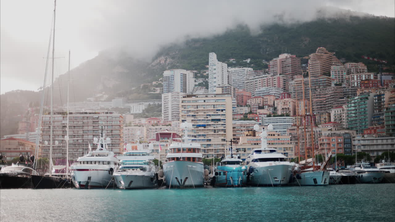 View of boats docked in the Monaco Marina with the skyline of the city on the background