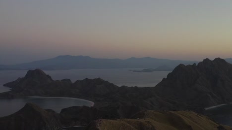 Aerial-footage-of-Padar-Island-at-sunset,-known-for-its-rugged-hills-and-beautiful-virgin-sandy-Beaches