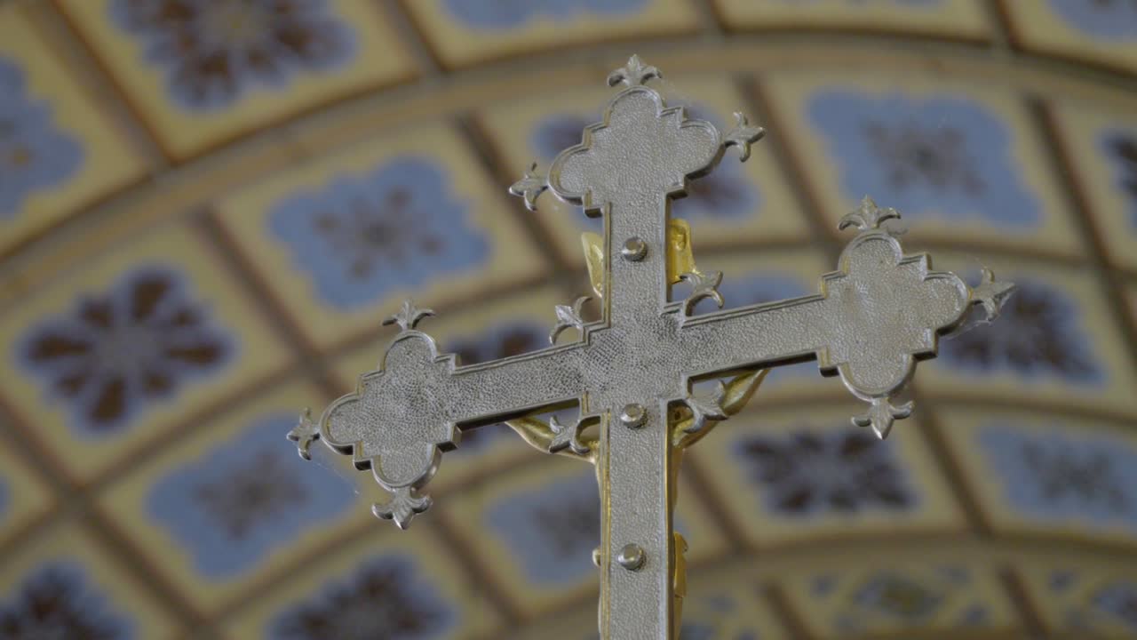 primer plano de una cruz de pie en una basílica histórica durante ceremonias religiosas